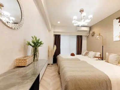 a hotel room with two beds and a mirror at G53\u65b0\u5bbf\u6700\u4e2d\u5fc3 \u6771\u65b0\u5bbf\u7ad95\u5206-Shinjuku center 5 mins to Station, Max 4P \u76f4\u8fbe\u65b0\u5bbf \u6d89\u8c37 \u8868\u53c2\u9053 \u6c60\u888b \u4e0a\u91ce \u4ee3\u4ee3\u6728 \u94f6\u5ea7 \u539f\u5bbf in Tokyo