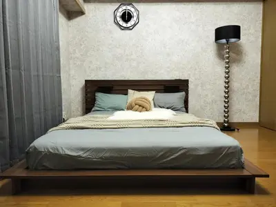 a bedroom with a large bed with a wooden headboard at B25\u65b0\u5bbf\u6700\u4e2d\u5fc3 \u65b0\u5bbf\u7ad910\u5206-Shinjuku center 10 mins to Station, Max 4 \u76f4\u8fbe\u65b0\u5bbf \u6d89\u8c37 \u8868\u53c2\u9053 \u6c60\u888b \u4e0a\u91ce \u4ee3\u4ee3\u6728 \u94f6\u5ea7 \u539f\u5bbf in Tokyo