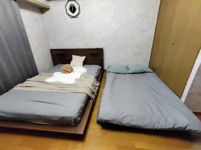 two beds sitting next to each other in a room at B25\u65b0\u5bbf\u6700\u4e2d\u5fc3 \u65b0\u5bbf\u7ad910\u5206-Shinjuku center 10 mins to Station, Max 4 \u76f4\u8fbe\u65b0\u5bbf \u6d89\u8c37 \u8868\u53c2\u9053 \u6c60\u888b \u4e0a\u91ce \u4ee3\u4ee3\u6728 \u94f6\u5ea7 \u539f\u5bbf in Tokyo