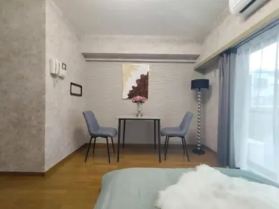 a bedroom with two chairs and a table with a vase of flowers at B25\u65b0\u5bbf\u6700\u4e2d\u5fc3 \u65b0\u5bbf\u7ad910\u5206-Shinjuku center 10 mins to Station, Max 4 \u76f4\u8fbe\u65b0\u5bbf \u6d89\u8c37 \u8868\u53c2\u9053 \u6c60\u888b \u4e0a\u91ce \u4ee3\u4ee3\u6728 \u94f6\u5ea7 \u539f\u5bbf in Tokyo