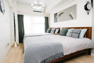 a bedroom with two beds and a clock on the wall at D91\u65b0\u5bbf\u6700\u4e2d\u5fc3 \u6771\u65b0\u5bbf\u7ad95\u5206-Shinjuku center 5 mins to Station, Max 4P \u76f4\u8fbe\u65b0\u5bbf \u6d89\u8c37 \u8868\u53c2\u9053 \u6c60\u888b \u4e0a\u91ce \u4ee3\u4ee3\u6728 \u94f6\u5ea7 \u539f\u5bbf in Tokyo