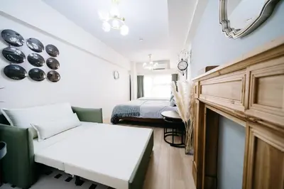 a room with two beds and a couch and a mirror at D91\u65b0\u5bbf\u6700\u4e2d\u5fc3 \u6771\u65b0\u5bbf\u7ad95\u5206-Shinjuku center 5 mins to Station, Max 4P \u76f4\u8fbe\u65b0\u5bbf \u6d89\u8c37 \u8868\u53c2\u9053 \u6c60\u888b \u4e0a\u91ce \u4ee3\u4ee3\u6728 \u94f6\u5ea7 \u539f\u5bbf in Tokyo