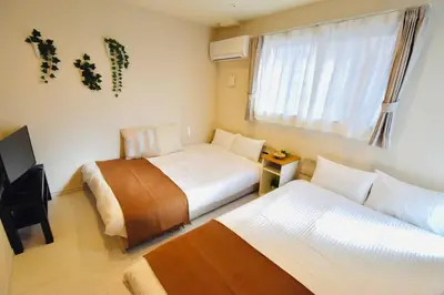 a hotel room with two beds and a television at Craft302 \u6d45\u8349 \u30b9\u30ab\u30a4\u30c4\u30ea\u30fc\u8fd1\u304f \u8cb8\u5207\u6700\u59275\u4eba \u6771\u4eac\u89b3\u5149\u306b\u6700\u9069 \u7121\u6599WiFi in Tokyo