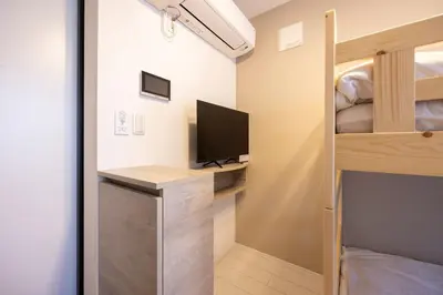 a bedroom with a bunk bed and a desk with a computer at Retaw Hills WASEDA in Tokyo