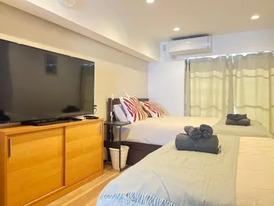 a bedroom with two beds and a large flat screen tv at JUN-shinjuku 4F-SJ0094 in Tokyo
