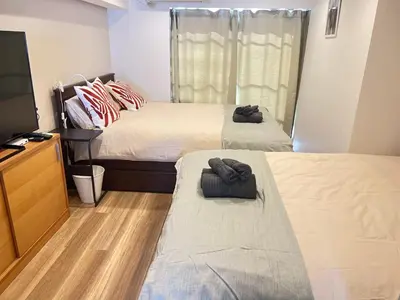 a bedroom with two beds and a flat screen tv at JUN-shinjuku 4F-SJ0094 in Tokyo