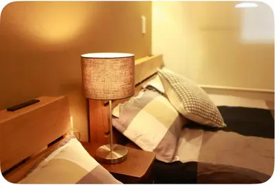 a bedroom with a bed with a lamp next to it at \u65b0\u5c0f\u5ca9\u99c5\u5f92\u6b695\u5206\u96fb\u8eca\u3067\u6771\u4eac\u99c513\u5206\u65b0\u5bbf\u99c530\u5206\u30c7\u30a3\u30ba\u30cb\u30fc\u307e\u306730\u5206\u6210\u7530\u30a8\u30af\u30b9\u30d7\u30ec\u30b9\u306765\u5206\u76f4\u901a in Tokyo