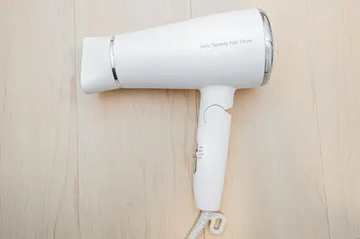a white hair dryer hanging on a wall at \u65b0\u5c0f\u5ca9\u99c5\u5f92\u6b695\u5206\u96fb\u8eca\u3067\u6771\u4eac\u99c513\u5206\u65b0\u5bbf\u99c530\u5206\u30c7\u30a3\u30ba\u30cb\u30fc\u307e\u306730\u5206\u6210\u7530\u30a8\u30af\u30b9\u30d7\u30ec\u30b9\u306765\u5206\u76f4\u901a in Tokyo