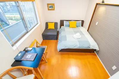 a small bedroom with a bed and a desk at \u65b0\u5c0f\u5ca9\u99c5\u5f92\u6b695\u5206\u96fb\u8eca\u3067\u6771\u4eac\u99c513\u5206\u65b0\u5bbf\u99c530\u5206\u30c7\u30a3\u30ba\u30cb\u30fc\u307e\u306730\u5206\u6210\u7530\u30a8\u30af\u30b9\u30d7\u30ec\u30b9\u306765\u5206\u76f4\u901a in Tokyo