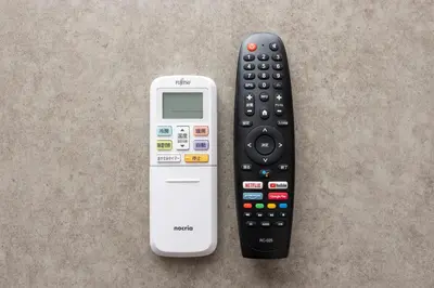 a remote control and a cell phone sitting on a table at Noble Park KINSHICHO in Tokyo