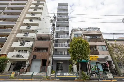 an apartment building on the corner of a street at Noble Park KINSHICHO in Tokyo