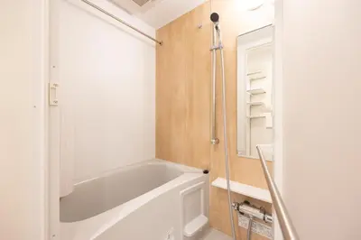 a bathroom with a bath tub and a mirror at Noble Park KINSHICHO in Tokyo