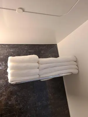 four white towels on a towel rack in a bathroom at 301\u53f7N\uff0b\u30db\u30c6\u30eb in Tokyo