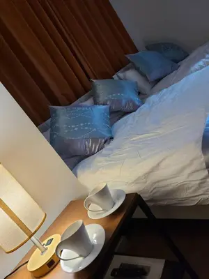 a bed with blue pillows and hats on a table at 301\u53f7N\uff0b\u30db\u30c6\u30eb in Tokyo