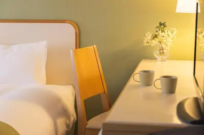 a bedroom with a bed and a table with a vase of flowers at Shinjuku Washington Hotel Annex in Tokyo