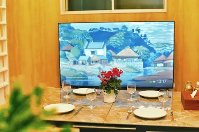a table with plates and wine glasses and a tv at kameido k hotel in Tokyo