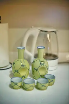 three green vases and four bowls on a table at kameido k hotel in Tokyo