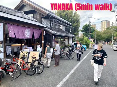 a group of people walking down a street at \u4e0a\u91ce\u685c\u6728 in Tokyo