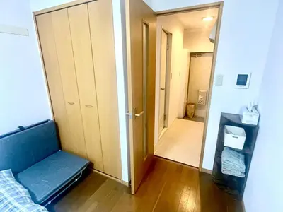 a room with a bed and a hallway with a mirror at Shibuya Honmachi Hana House in Tokyo