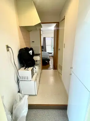 a hallway with a room with boxes and a backpack at Shibuya Honmachi Hana House in Tokyo