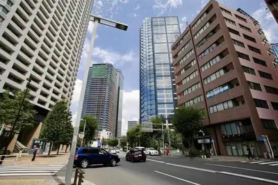 a city street with cars driving down a street with tall buildings at Shibuya Honmachi Hana House in Tokyo
