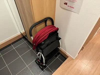 a red suitcase sitting on the floor next to a door at Relastay Kamata in Tokyo