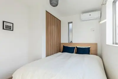 a bedroom with a large white bed with blue pillows at Relastay Kamata in Tokyo