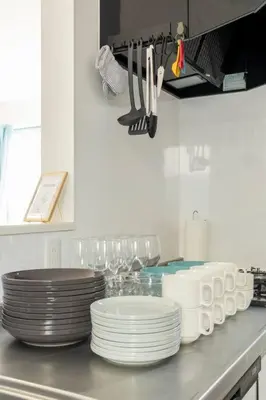 a kitchen counter with plates and utensils on it at Relastay Kamata in Tokyo