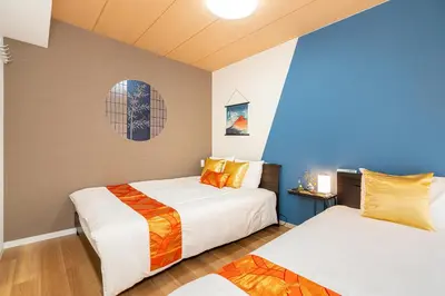 two beds in a room with blue walls at KYARA Hotel\u30df\u30b9\u30df301 in Tokyo