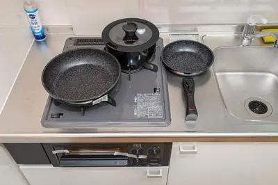 a kitchen counter with two pans and a sink at KYARA Hotel\u30df\u30b9\u30df301 in Tokyo