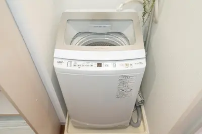 a washing machine in the corner of a room at KYARA Hotel\u30df\u30b9\u30df301 in Tokyo