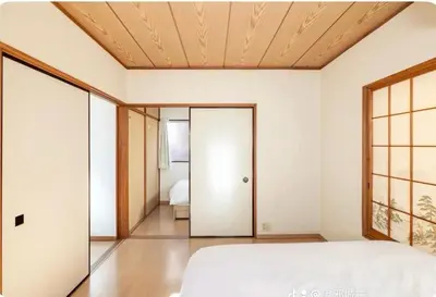 a bedroom with white walls and a wooden ceiling at \u5c0f\u7af9\u306e\u5bbf\u65e5\u5f0f\u72ec\u680b\u4e09\u95f4\u5367\u5ba4\u6c60\u888b\u5730\u94c1\u4e94\u7ad9 in Tokyo
