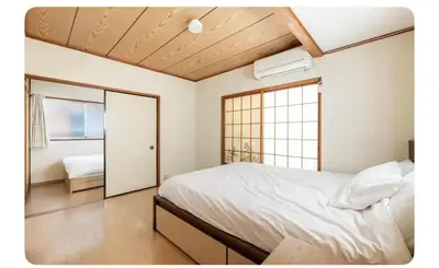 a bedroom with a white bed and a window at \u5c0f\u7af9\u306e\u5bbf\u65e5\u5f0f\u72ec\u680b\u4e09\u95f4\u5367\u5ba4\u6c60\u888b\u5730\u94c1\u4e94\u7ad9 in Tokyo