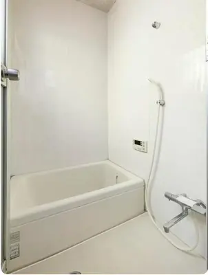 a white bathroom with a tub and a sink at \u5c0f\u7af9\u306e\u5bbf\u65e5\u5f0f\u72ec\u680b\u4e09\u95f4\u5367\u5ba4\u6c60\u888b\u5730\u94c1\u4e94\u7ad9 in Tokyo