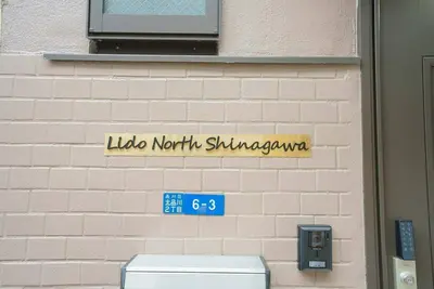 a sign on the side of a brick wall at Lido North Shinagawa in Tokyo