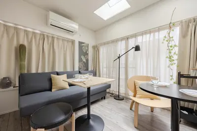 a living room with a blue couch and a table at Lido East Shinagawa\u3000 in Tokyo