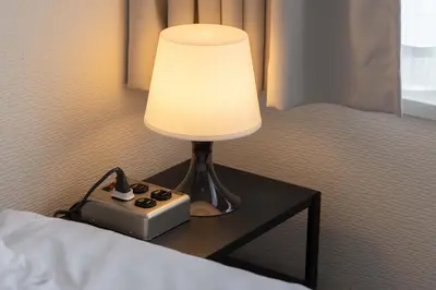 a lamp sitting on a table next to a bed at Lido East Shinagawa\u3000 in Tokyo