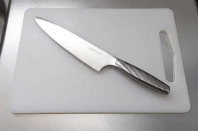 a knife sitting on top of a white cutting board at Lido East Shinagawa\u3000 in Tokyo