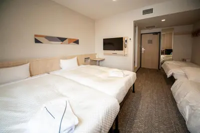a row of beds in a hotel room at Hotel Il Fiore Kasai Annex in Tokyo