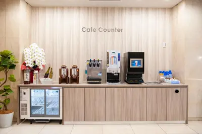 a cafe counter with a coffee maker on top of it at Hotel Il Fiore Kasai Annex in Tokyo