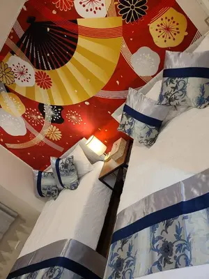 a bedroom with a bed with a colorful wall at 303\u53f7\uff2e\uff0b\u30db\u30c6\u30eb in Tokyo