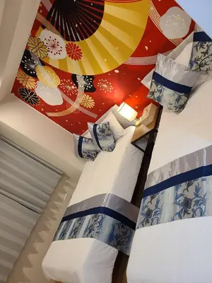 a bedroom with two beds with a mural on the wall at 303\u53f7\uff2e\uff0b\u30db\u30c6\u30eb in Tokyo