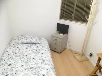 a bedroom with a bed and a computer on a dresser at Tokyo Center Ikebukuro Family villa quiet 4BR group stay & parking near JR in Tokyo