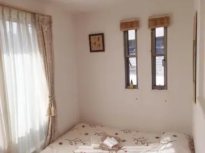 a bedroom with a bed and three windows at Tokyo Center Ikebukuro Family villa quiet 4BR group stay & parking near JR in Tokyo