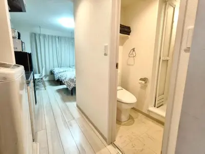 a bathroom with a toilet and a room with a bed at \u30c6\u30a3\u30a8\u30e9\u5317\u6c60\u888b in Tokyo