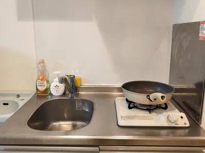 a pan sitting on a stove next to a sink at \u30c6\u30a3\u30a8\u30e9\u5317\u6c60\u888b in Tokyo
