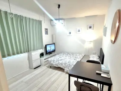 a room with a bed and a desk and a television at \u30c6\u30a3\u30a8\u30e9\u5317\u6c60\u888b in Tokyo