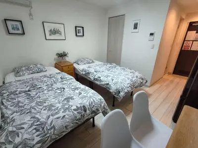 a bedroom with two beds and a table at \u30c6\u30a3\u30a8\u30e9\u5317\u6c60\u888b in Tokyo