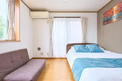 a bedroom with two beds and a couch at J-2S JR Yamanote Komagome, 3 storey 101sq 4BR, FreePark in Tokyo