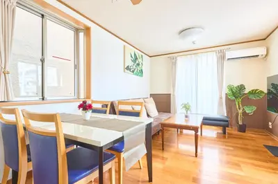 a living room with a table and chairs and a couch at J-2S JR Yamanote Komagome, 3 storey 101sq 4BR, FreePark in Tokyo
